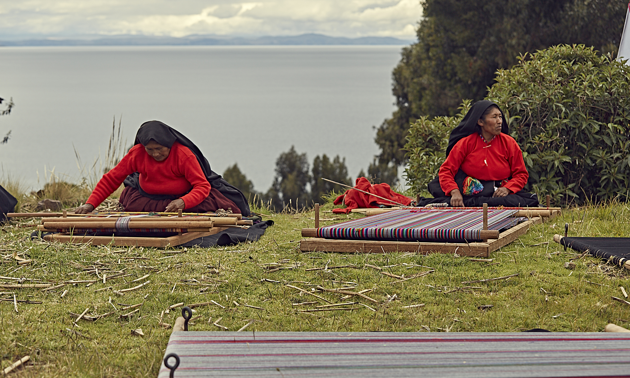 Two women operate traditional looms in Peru