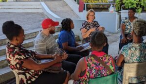 A woman speakers to a circle of trainees